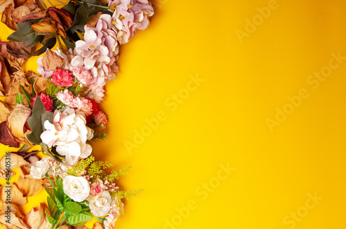 wedding invitation with yellow background on flowers and petals located on the left side © Yanchapaxi