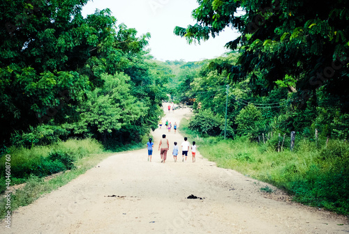 people walking on a dirt path in a rural area 