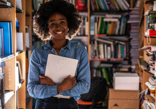 Portrait of young black female student .She standing in college library.	
