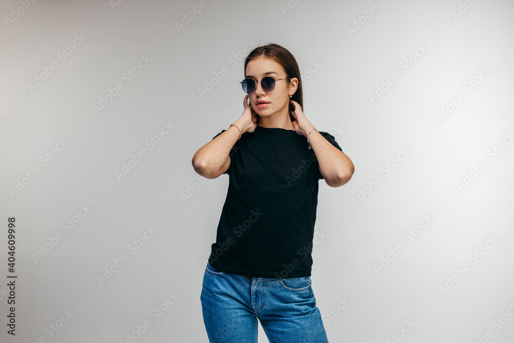 Stylish girl in glasses wearing black t-shirt posing in studio Stylish girl in glasses wearing black t-shirt posing in studio