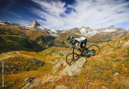 Women on a mountainbike drives down the wallis mountains for the matterhorn in the swiss alps © Thomas