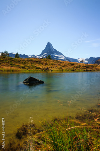 Matterhorn view with shining sun on a good summer day and clouds lake with sea photo