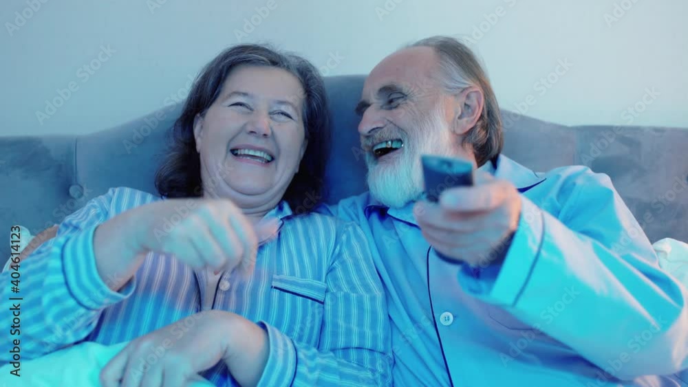 Cheerful couple watching comedy together, having fun, home cinema, television Cheerful couple watching comedy together, having fun, home cinema, television