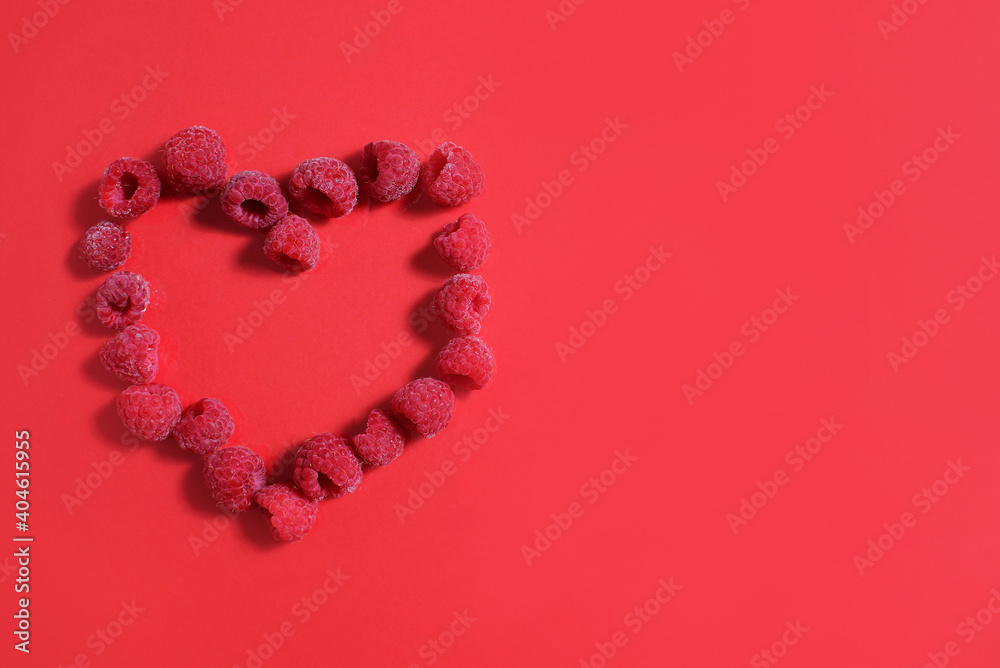 Red heart made from frozen raspberries on a red background. valentine's day convenience food concept. Red heart made from frozen raspberries on a red background. valentine's day convenience food concept.