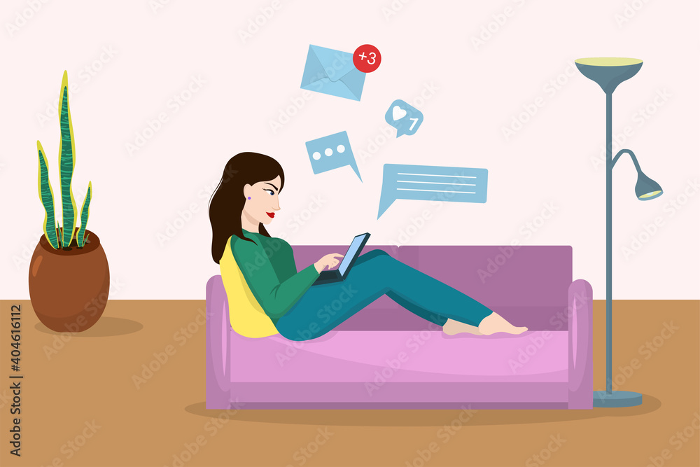 Obraz premium young brunette woman working on laptop lying on sofa. Concept of working from home and freelancing