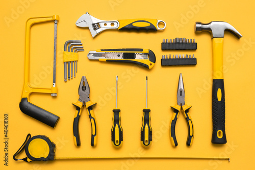 Construction tools on the yellow flat lay background.