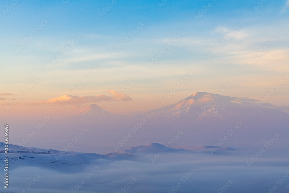 Beautiful sunrise with long exposure clouds. The mountains in a clouds and fog. Ararat mountain.