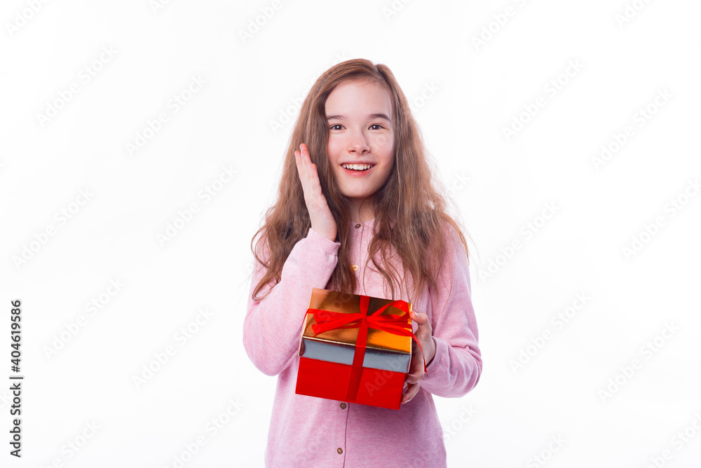 Surprised young girl smiling and holding a gift box over white background. Surprised young girl smiling and holding a gift box over white background.