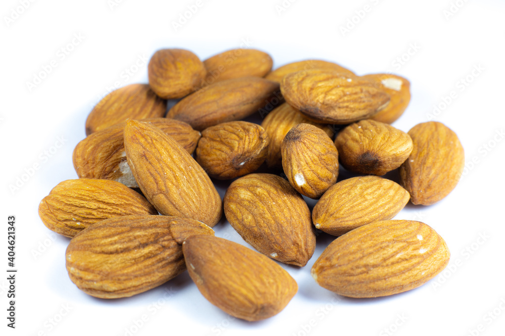 Almond nuts lying on white background. Healthy sport food. Vegan concept. Close up. Almond nuts lying on white background. Healthy sport food. Vegan concept. Close up.