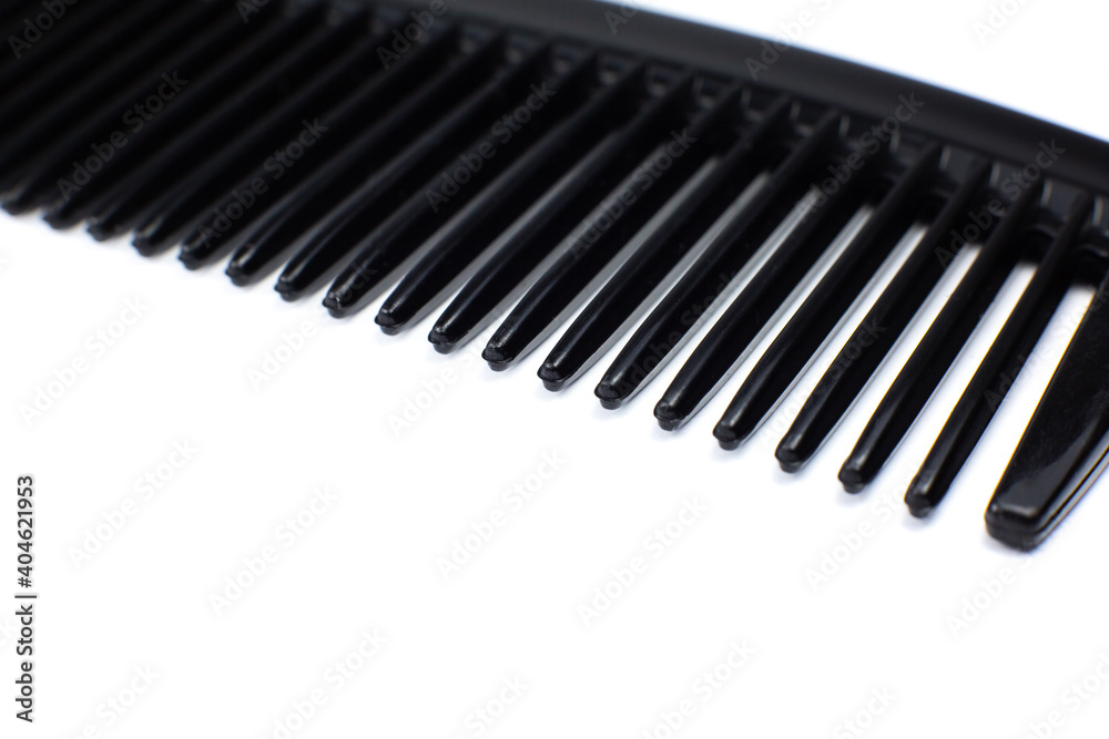 Black comb on white background. Close up.