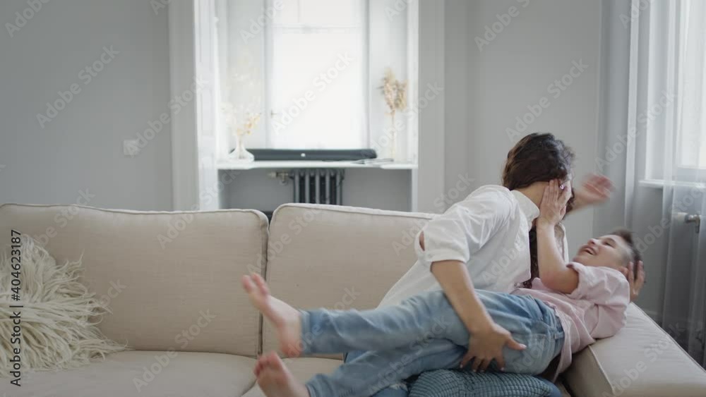 Young Mother And Son On The Couch. Mom Hugs The Boy. They Have Fun. Young Mother And Son On The Couch. Mom Hugs The Boy. They Have Fun.