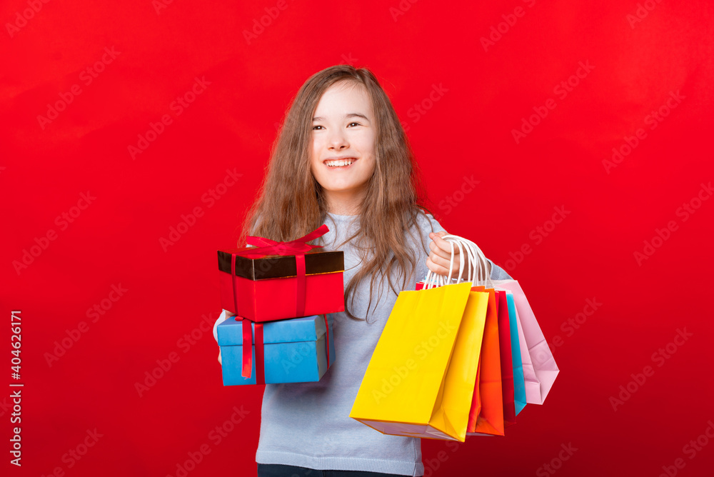 Happy child holding two gift boxes and many colorful shopping bags and looking away. Happy child holding two gift boxes and many colorful shopping bags and looking away.