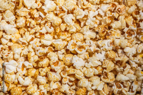 Heap of delicious popcorn, isolated on white background. Scattered popcorn texture background. Top view.popcorn with caramel