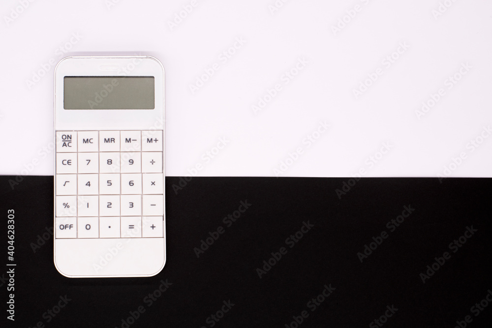 White calculator on a black and white background. Business concept White calculator on a black and white background. Business concept