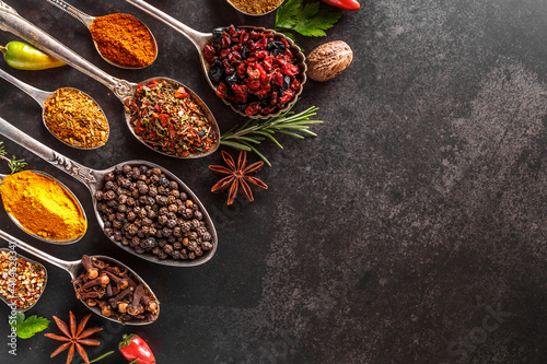 Fototapeta Naklejka Na Ścianę i Meble -  Various spices a vintage spoons on stone table. Colorful Herbal and Spices Oriental marketplace.Top view . Cafe concept. Delicious food delivery.