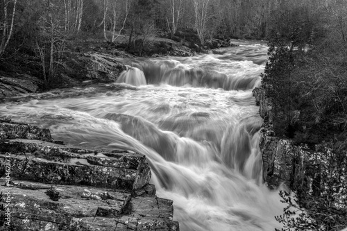 long exposure in mono of a swollen river in the Scottish Highlands
