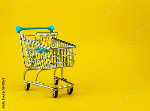 Empty shopping cart isolated on yellow background with copyspace. Retail store concept