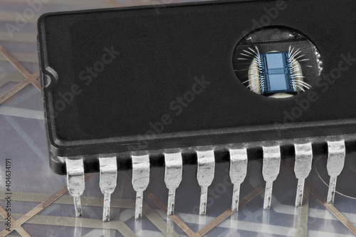 Computer erasable programmable read-only memory chip on flex PCB membrane detail. Digital EPROM integrated circuit with round window to erase data by UV light. Thin silver wires on die in DIP package. photo