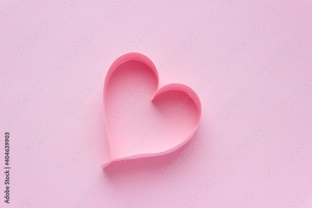 Beautiful pink paper heart on pink background with copy space. Quilling, origami, handmade. Minimalism