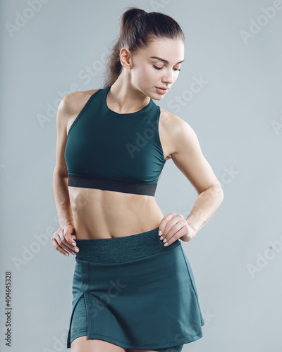 Portrait of a beautiful sports woman on gray background © pridneprovskiy