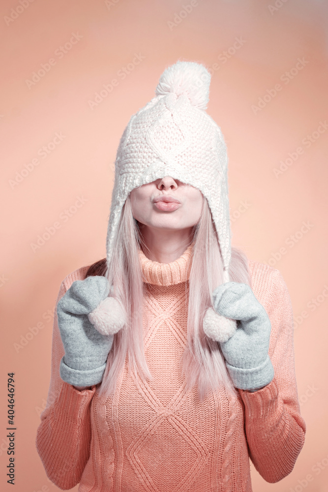 elegant young girl in a winter hat, warm sweater and mittens