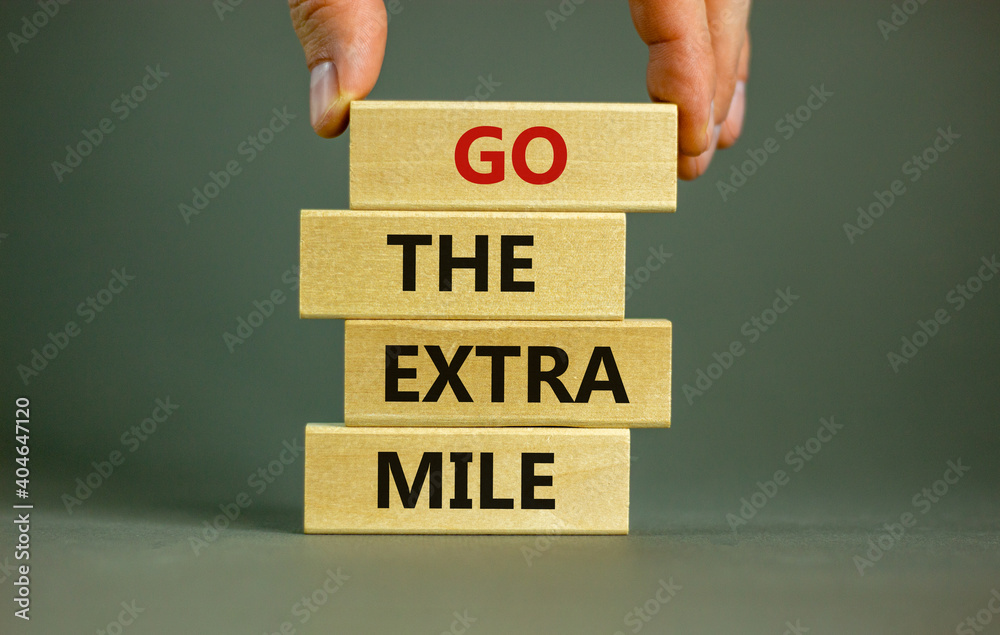 Go the extra mile symbol. Wooden blocks with words 'Go the extra mile