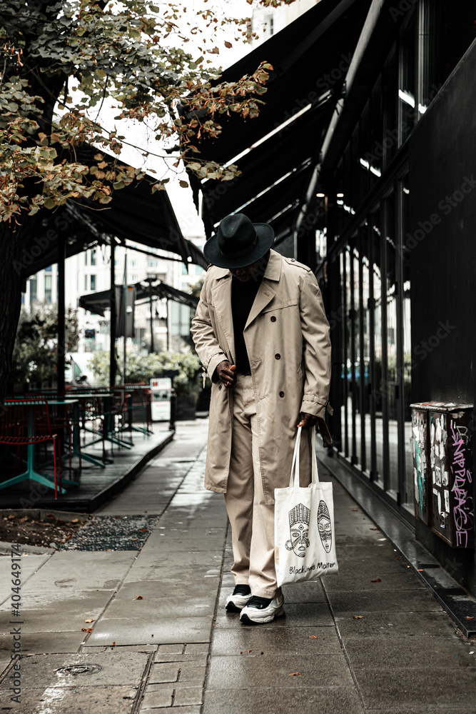 Obraz premium Fashion black man walking on street. Fashionable portrait of african american male model. Street style
