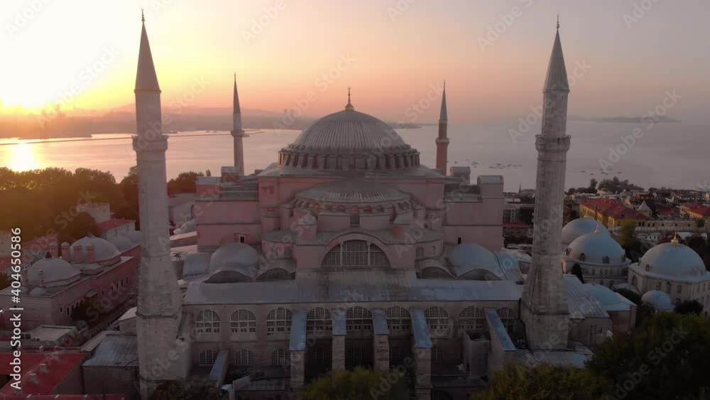 Establishing aerial drone shot of a Hagia Sophia Holy Grand Mosque (Ayasofya Camii) with Bosphorus and city skyline on the background in Fatih, Istanbul, Turkey at sunrise