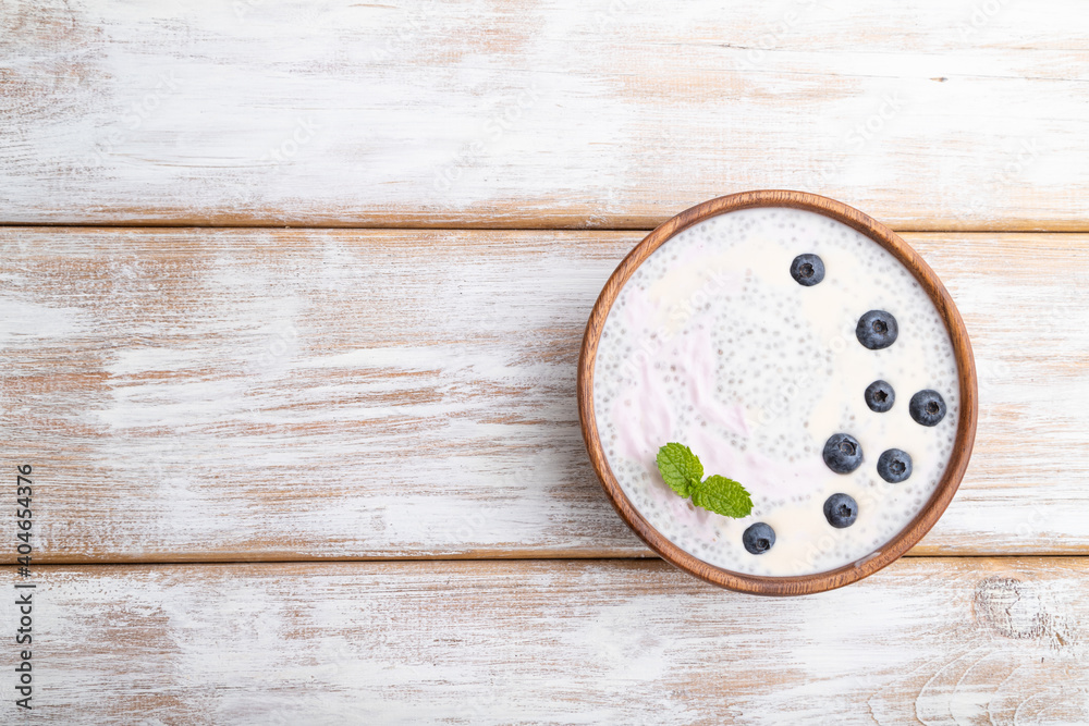 Yogurt with blueberry in wooden bowl on white wooden background. top view, copy space. Yogurt with blueberry in wooden bowl on white wooden background. top view, copy space.