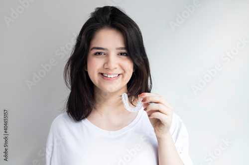Close-up Of A Girl's Hand Putting Transparent Aligner In Teeth 