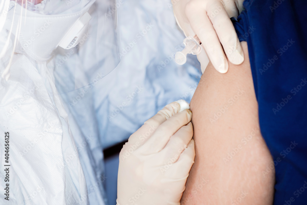 Doctor or nurse wearing ppe suit, mask, face shield, gloves are injection covid 19 vaccine to people on upper arm.Vaccine COVID-19 injected for stimulating the immunity against COVID-19 Doctor or nurse wearing ppe suit, mask, face shield, gloves are injection covid 19 vaccine to people on upper arm.Vaccine COVID-19 injected for stimulating the immunity against COVID-19