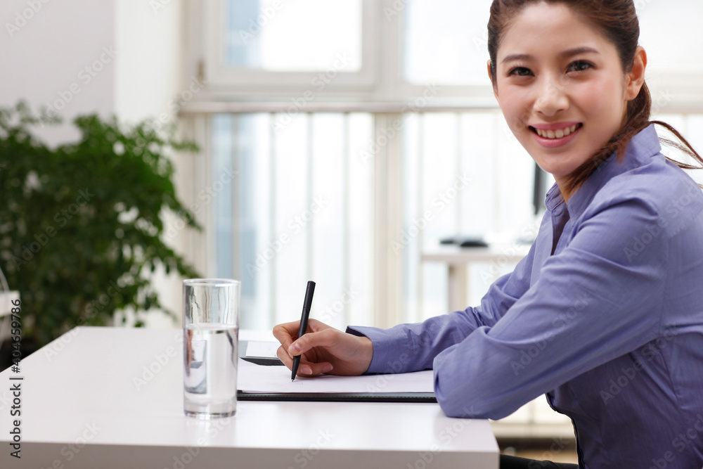 A young Business woman writing on portfolio A young Business woman writing on portfolio