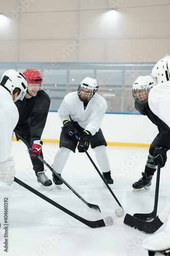 Photography Group of professional hockey players in skates standing in circle on ice rink