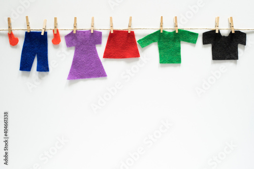 Felt clothes hanging on rope on white background. Art craft creative concept with empty space for text.