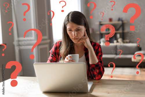 Photos Woman teleworker works at home with a laptop but has some questions