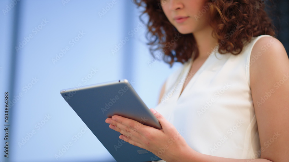 Charming girl surfing internet on tablet. Beautiful lady using device outside.