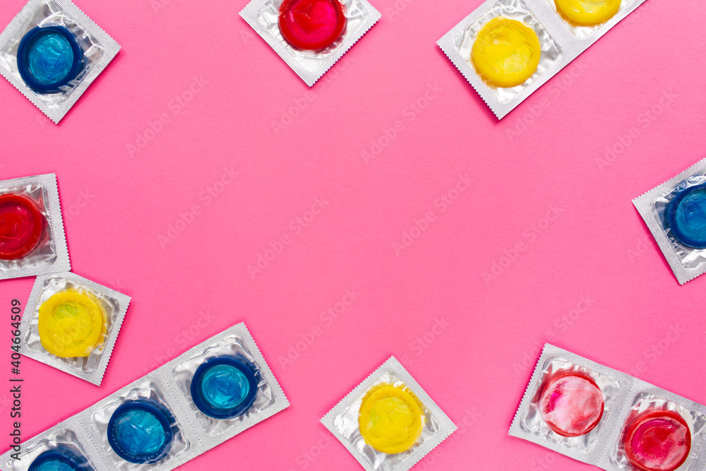 Composition with colorful condoms on bright pink background. Safe sex and contraceptive concept. Flat lay, top view, copy space. - obrazy, fototapety, plakaty 