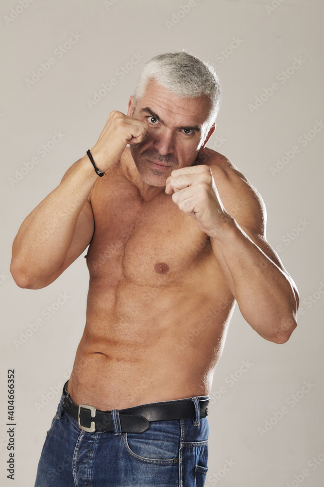 the muscular male holds his fists and is ready for battle the muscular male holds his fists and is ready for battle