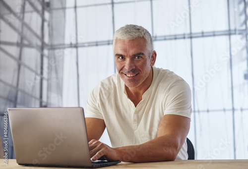 Middle-aged man working from office on laptop