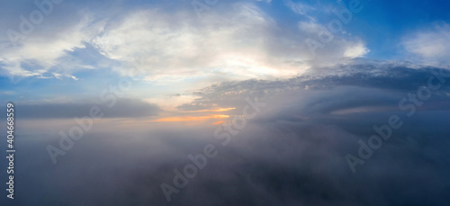 Panorama of misty cloud high in the sky at dawn. Aerial view.