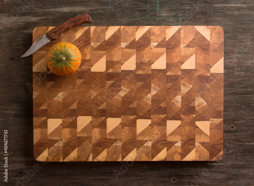 End cutting board made of oak and apple wood. Pumpkin and knife.