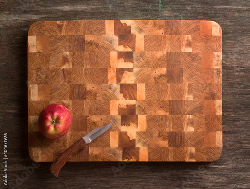End cutting board made of oak and apple wood. Apple and knife.