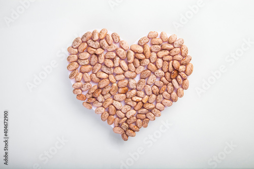 heart made of raw pinto beans on white background, healthy life and nutrition concept photo