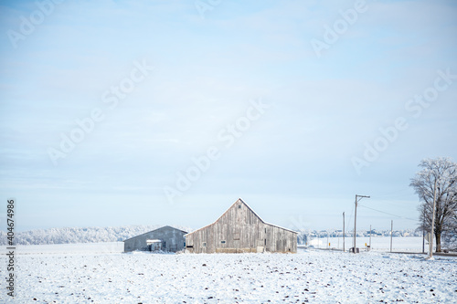 old weathered barns on snow covered midwest farm