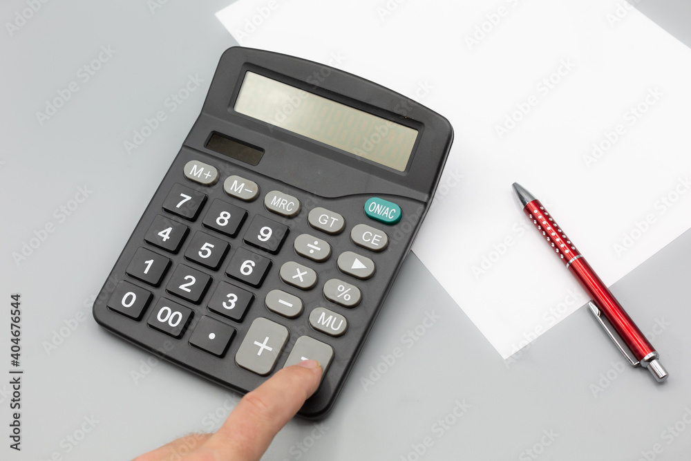 calculator on desk with grey background, pen paper calculator on desk with grey background, pen paper