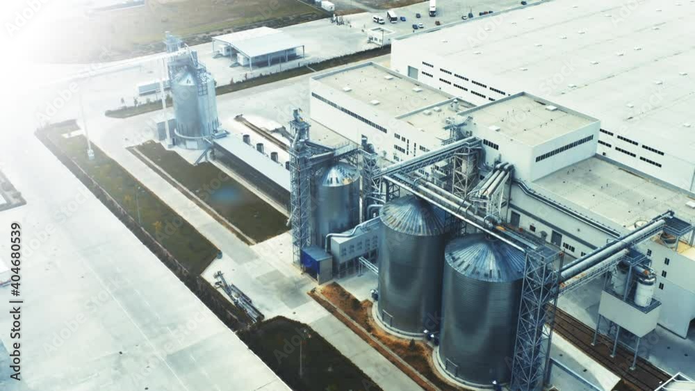 Production plant for wood processing and silos for drying firewood and lumber. Metal silo on the high-tech factory. Aerial view Production plant for wood processing and silos for drying firewood and lumber. Metal silo on the high-tech factory. Aerial view