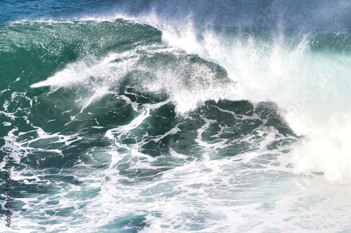 explosive surf across a white and green ocean.