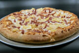Tangy pineapple tops the Hawaiian pizza with melted cheese for the specialty flavor.