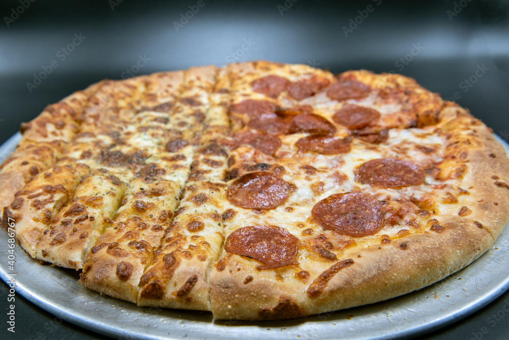 Unique pizza is half bread sticks and half pepperoni and cheese pizza,