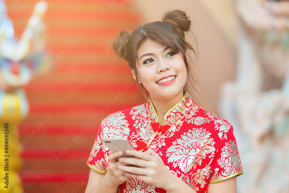 Happy asian woman in traditional Chinese clothing and writing message on smartphone and background blur Chinese architecture. Happy asian woman in traditional Chinese clothing and writing message on smartphone and background blur Chinese architecture.